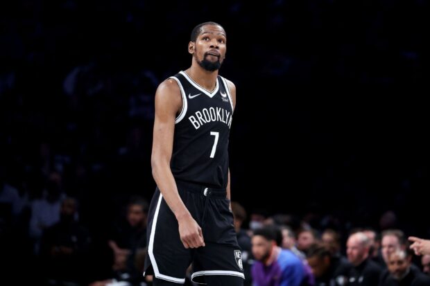 A Brooklyn Nets player is standing focused on the basketball court during a game, HD Desktop Wallpaper