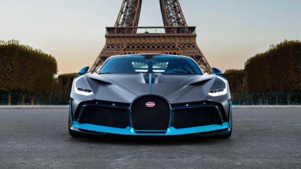 A Bugatti Divo sports car is parked in front of the Eiffel Tower during sunset, 2K Desktop Wallpaper