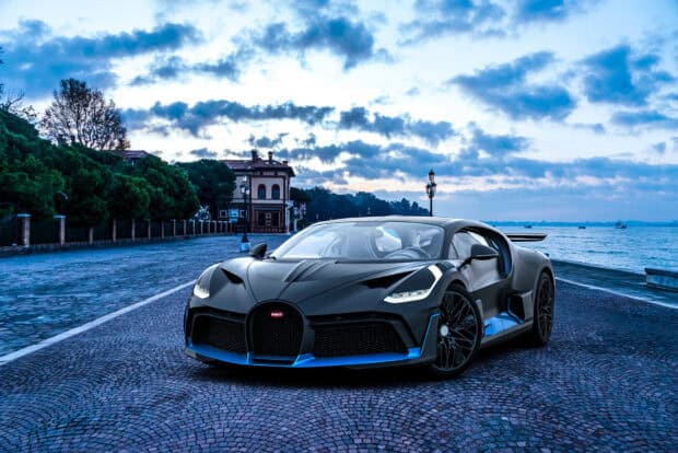 A Bugatti Divo car is parked on a coastal road near the water under a cloudy sky, HD Desktop Wallpaper
