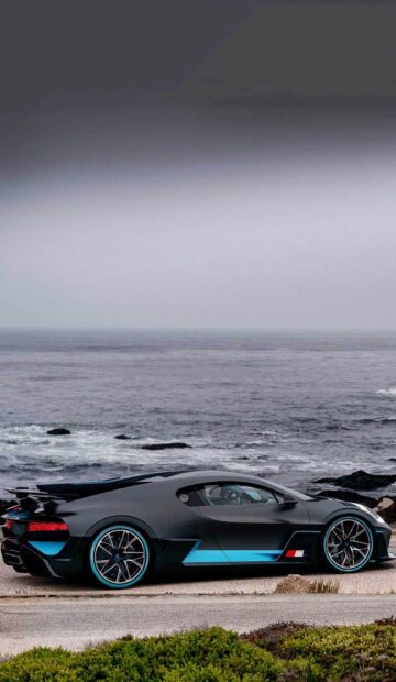 A Bugatti Divo is parked near the ocean with waves and cloudy sky visible, HD Phone Wallpaper