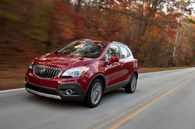 A red Buick Encore drives along a forest road during autumn, HD Desktop Wallpaper