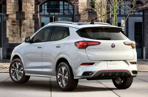 A white Buick Encore is parked in front of a building with stone walls and windows, HD Desktop Wallpaper