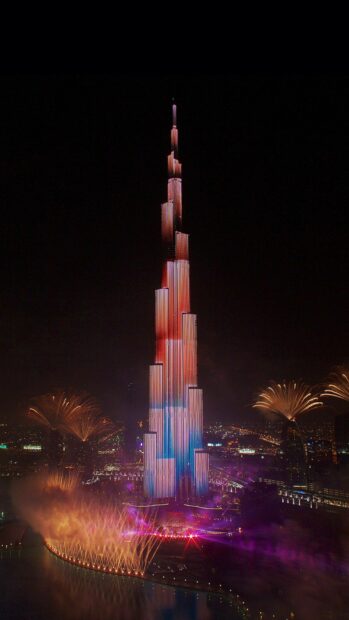 The Burj Khalifa is lit with colorful lights during a nighttime celebration in Dubai, United Arab Emirates wallpapers, HD Phone Wallpaper