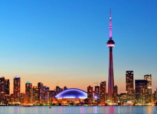 The CN Tower in Canada lights up the city skyline during dusk with colorful illumination, HD Desktop Wallpaper