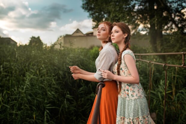 Two women enjoying a quiet moment in a lush village setting, 2K Desktop Wallpaper