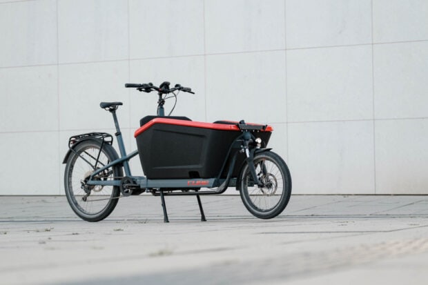 A sleek cargo bike from Cube Bikes is parked on pavement, HD Desktop Wallpaper