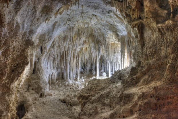 The image shows natural stalactites and cave formations inside Carlsbad Caverns National Park, 2K Desktop Wallpaper