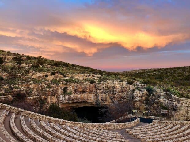 The Carlsbad Caverns National Park features a stone amphitheater at its entrance with a colorful sunset sky, HD Desktop Wallpaper
