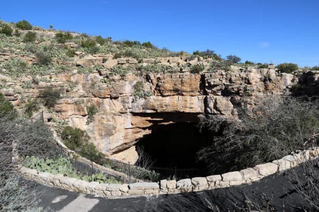 The entrance of Carlsbad Caverns National Park is surrounded by rocky terrain and clear blue sky, HD Desktop Wallpaper