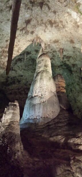 A towering rock formation inside Carlsbad Caverns National Park with stalactites hanging from the ceiling, 2K Phone Wallpaper