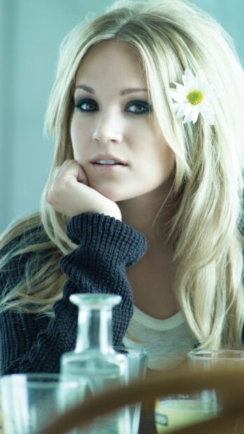 Carrie Underwood Wallpapers shows a close up of her face with a flower in her hair, HD Mobile Wallpaper