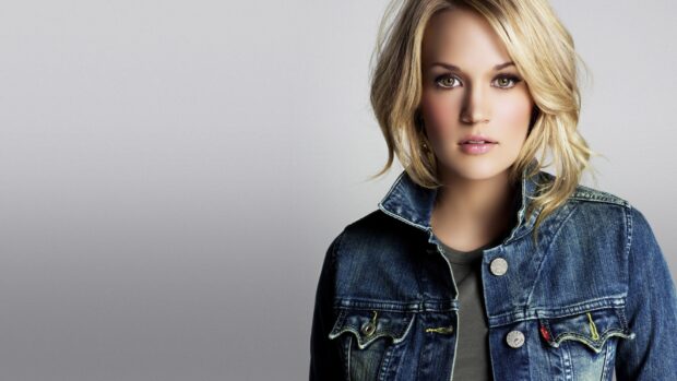 Carrie Underwood wears a denim jacket with a neutral expression on a grey background, HD Desktop Wallpaper