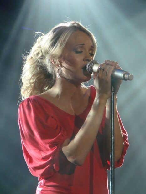 Carrie Underwood sings passionately into a microphone during a live performance, HD Phone Wallpaper