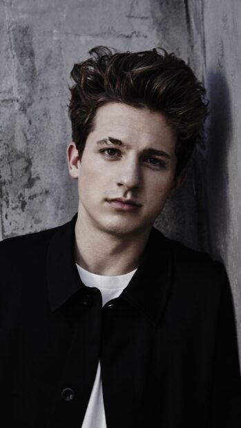 A close up portrait of Charlie Puth with a serious expression against a textured wall, HD Phone Wallpaper