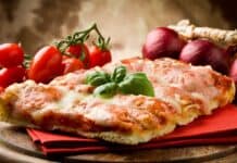 A close up of a cheesy pizza slice with fresh tomatoes and onions on a wooden table, 4K Desktop Wallpaper