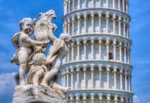 Cherubs holding a shield statue with the Tower of Pisa in the background under a clear blue sky, HD Desktop Wallpaper