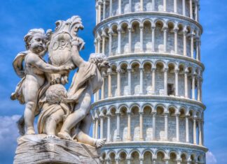 Cherubs holding a shield statue with the Tower of Pisa in the background under a clear blue sky, HD Desktop Wallpaper