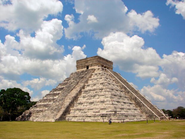 The Chichen Itza pyramid stands under a partly cloudy blue sky, 2K Desktop Wallpaper