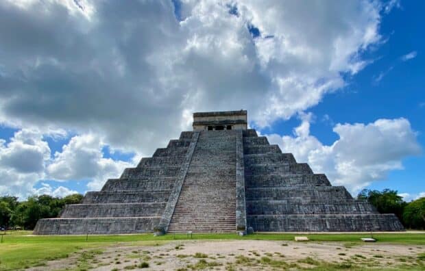 The Chichen Itza pyramid stands tall under a partly cloudy blue sky, 2K Desktop Wallpaper
