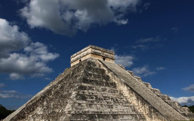 The Chichen Itza pyramid stands tall against a bright blue sky with scattered clouds, 2K Desktop Wallpaper