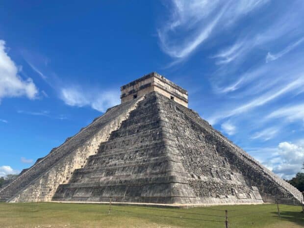 The ancient Chichen Itza pyramid stands under a blue sky with white clouds, 2K Desktop Wallpaper