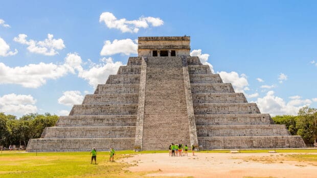 A group of tourists admires the Chichen Itza pyramid in bright daylight, HD Desktop Wallpaper