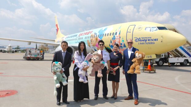 Staff posing in front of a China Eastern Airlines plane with Disney characters on it, HD Desktop Wallpaper