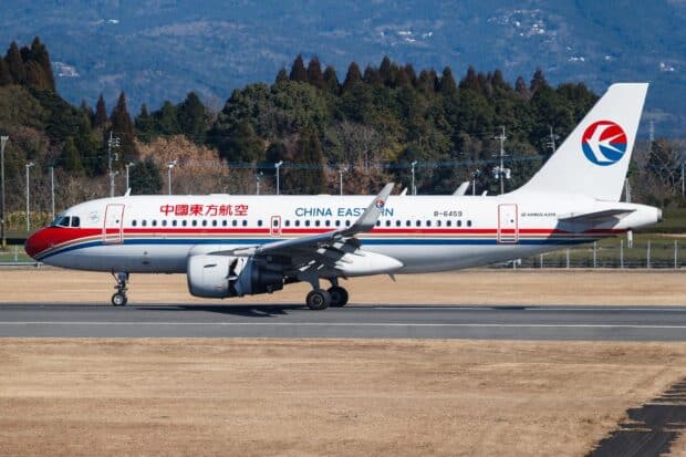 A China Eastern Airlines airplane is taxiing on the runway with a forest backdrop, HD Desktop Wallpaper