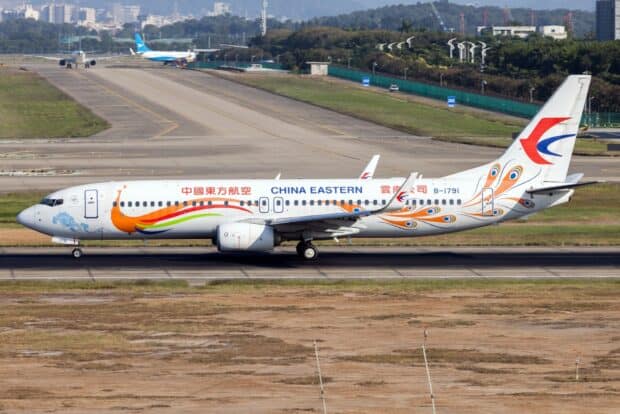 A China Eastern Airlines plane is taxiing on the airport runway with visible logo and colorful design, HD Desktop Wallpaper