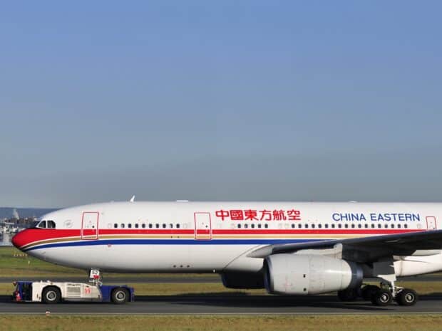 A China Eastern Airlines airplane is being towed on the airport runway under clear sky, HD Desktop Wallpaper