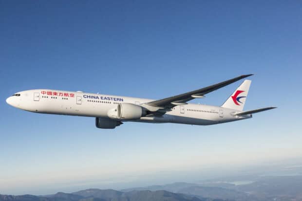 A China Eastern Airlines airplane flies over mountains with clear blue sky, 2K Desktop Wallpaper