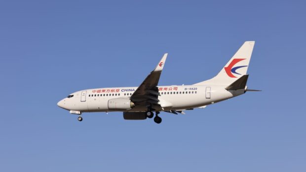 A China Eastern Airlines plane is flying against a clear blue sky, HD Desktop Wallpaper