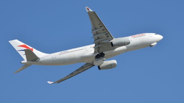 A China Eastern Airlines aircraft is flying against a bright blue sky, 2K Desktop Wallpaper