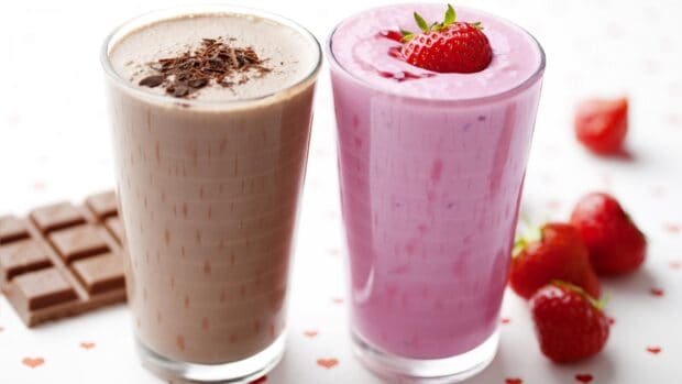 Two delicious milkshakes with chocolate and strawberry flavors on a table, 4K Desktop Wallpaper