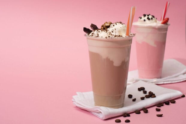 A close up of chocolate and strawberry milkshakes topped with cream and chocolate chips on a pink background, HD Desktop Wallpaper