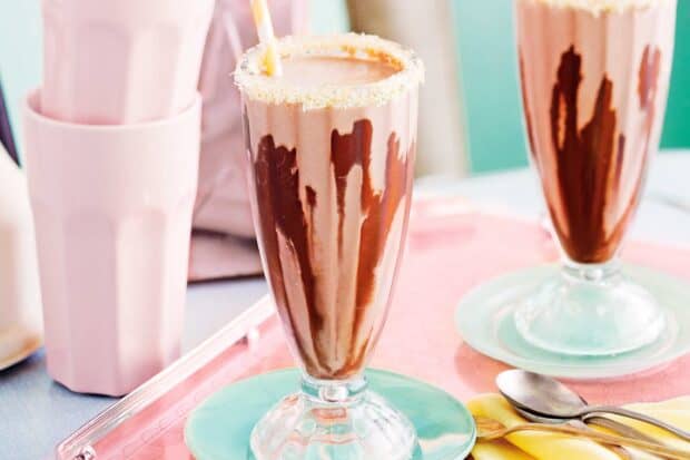 A chocolate milkshake with creamy topping and a sugar rim in a tall glass, 2K Desktop Wallpaper