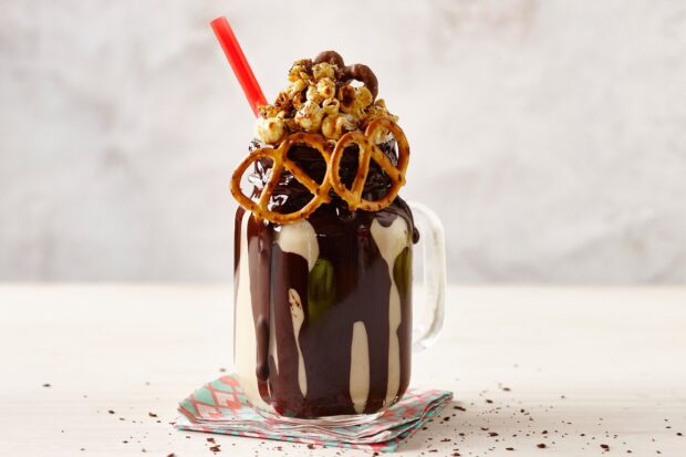A chocolate milkshake topped with popcorn and pretzels with a red straw, 2K Desktop Wallpaper