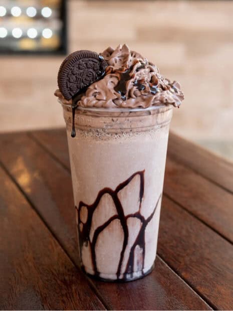 A chocolate milkshake with whipped cream, chocolate syrup, and a cookie on top, HD Mobile Wallpaper