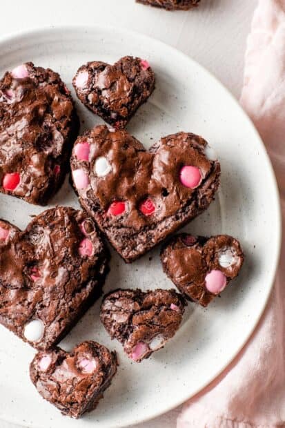 Chocolate heart shape desserts with red and pink candy pieces on a white plate, HD Mobile Wallpaper