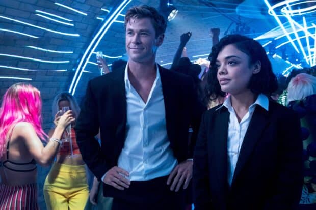 Chris Hemsworth and Tessa Thompson stand together in a vibrant party scene from Men In Black, 2K Desktop Wallpaper