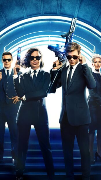 Chris Hemsworth and agents posing with futuristic weapons in Men In Black, 2K Mobile Wallpaper