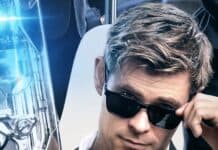 Chris Hemsworth in a black suit and sunglasses holding a futuristic weapon in a Men In Black setting, 2K Desktop Wallpaper