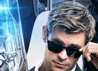 Chris Hemsworth in a black suit and sunglasses holding a futuristic weapon in a Men In Black setting, 2K Desktop Wallpaper