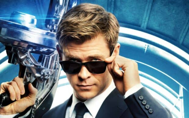 Chris Hemsworth in a suit adjusting his sunglasses in a Men In Black setting, 2K Desktop Wallpaper