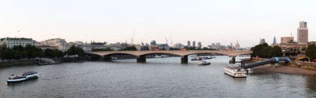 A ferry travels along the river in the city under the bridge at dusk, 4K Desktop Wallpaper