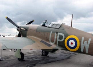 A Hawker Hurricane aircraft is parked on the tarmac under a cloudy sky, 2K Desktop Wallpaper
