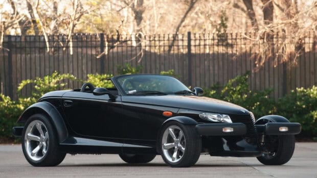 A black Plymouth Prowler car parked outdoors near a fence and trees, HD Desktop Wallpaper