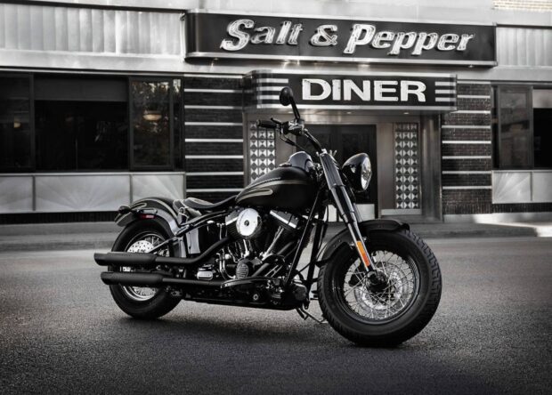 A black street bike is parked outside a classic diner with vintage signage, HD Desktop Wallpaper