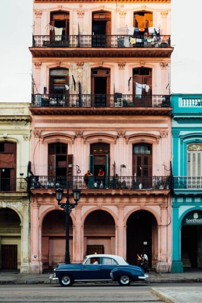 A vintage car drives past a pastel building with balconies in Havana Cuba with Havana Cuba Wallpapers, 2K Desktop Wallpaper