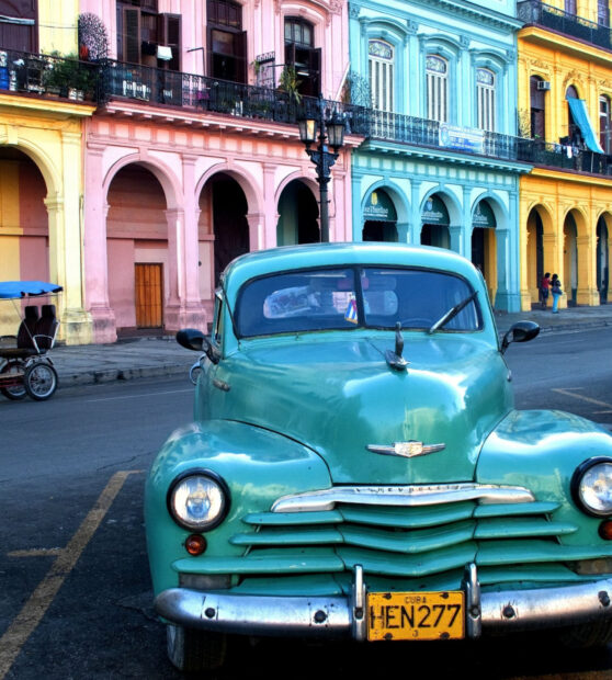 A turquoise vintage car parked in front of vibrant pastel buildings on a Havana Cuba street, HD Desktop Wallpaper